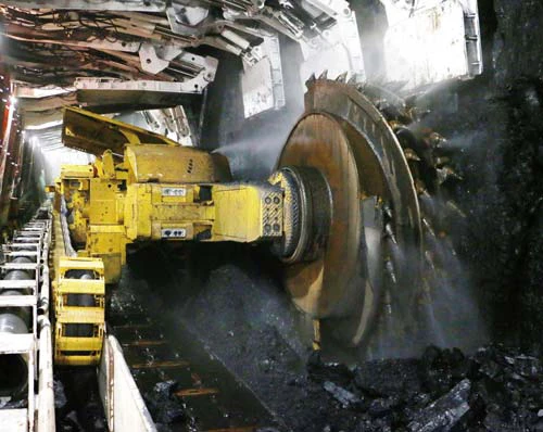 A coal cutter is currently coal mining underground.
